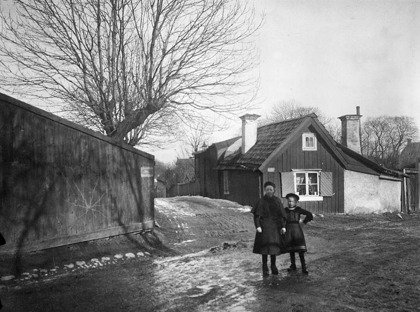 Flickorna står vid Bondegatan 79 och har Tegelviksgatan bakom sig. Här slutar Bondegatan idag med bl.a. en parkeringsplats. C:a 1885-1910 Foto och källa: Stadsmuseet